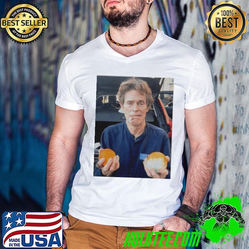 William dafoe smoking cigarette with two oranges one of them moldy shirt